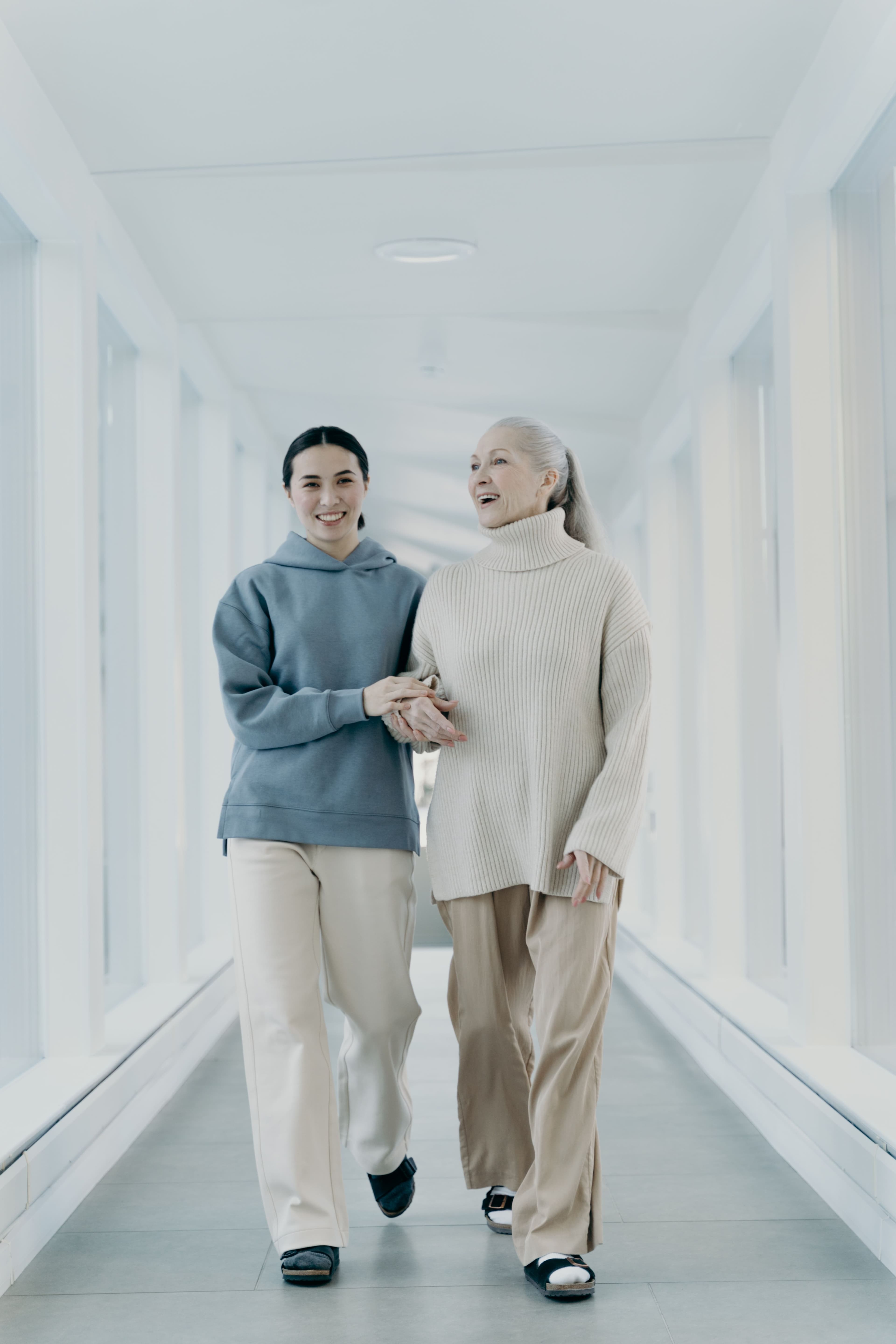Caregiver walking arm-in-arm with a smiling senior client